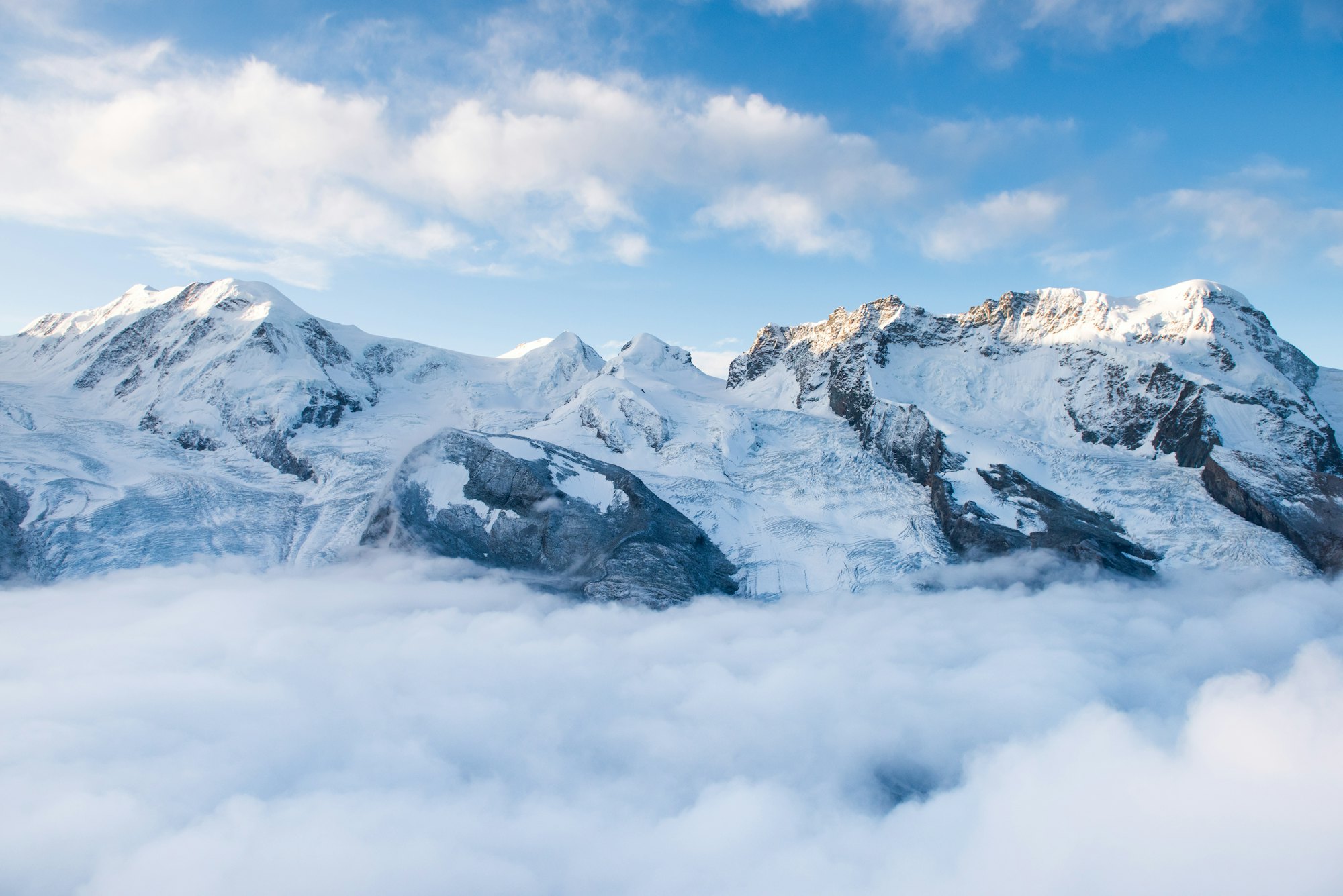 Snow peaks above a sea of cloud in the Alps